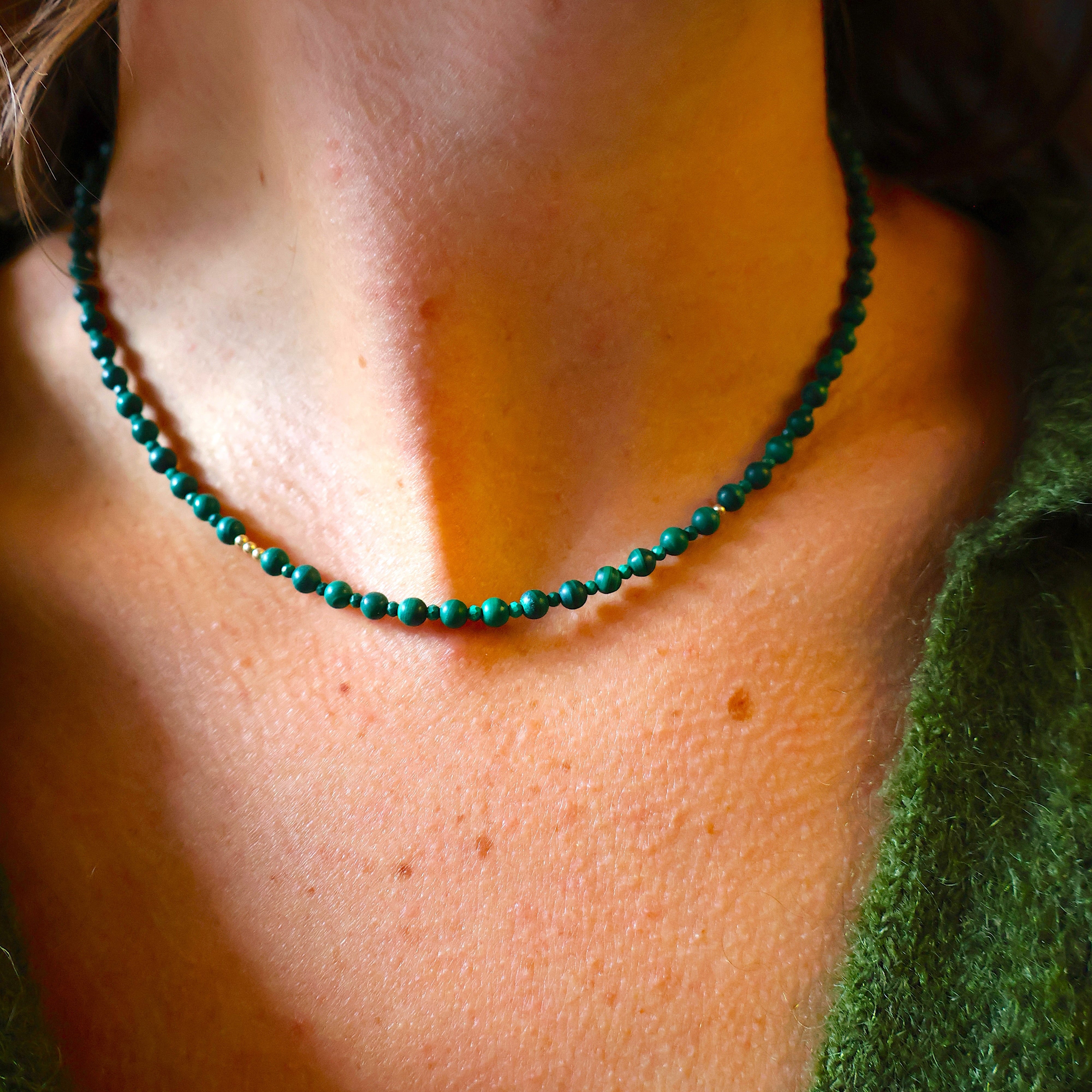 ketting van ronde groene en facet geslepen malachiet en goldfilled kralen