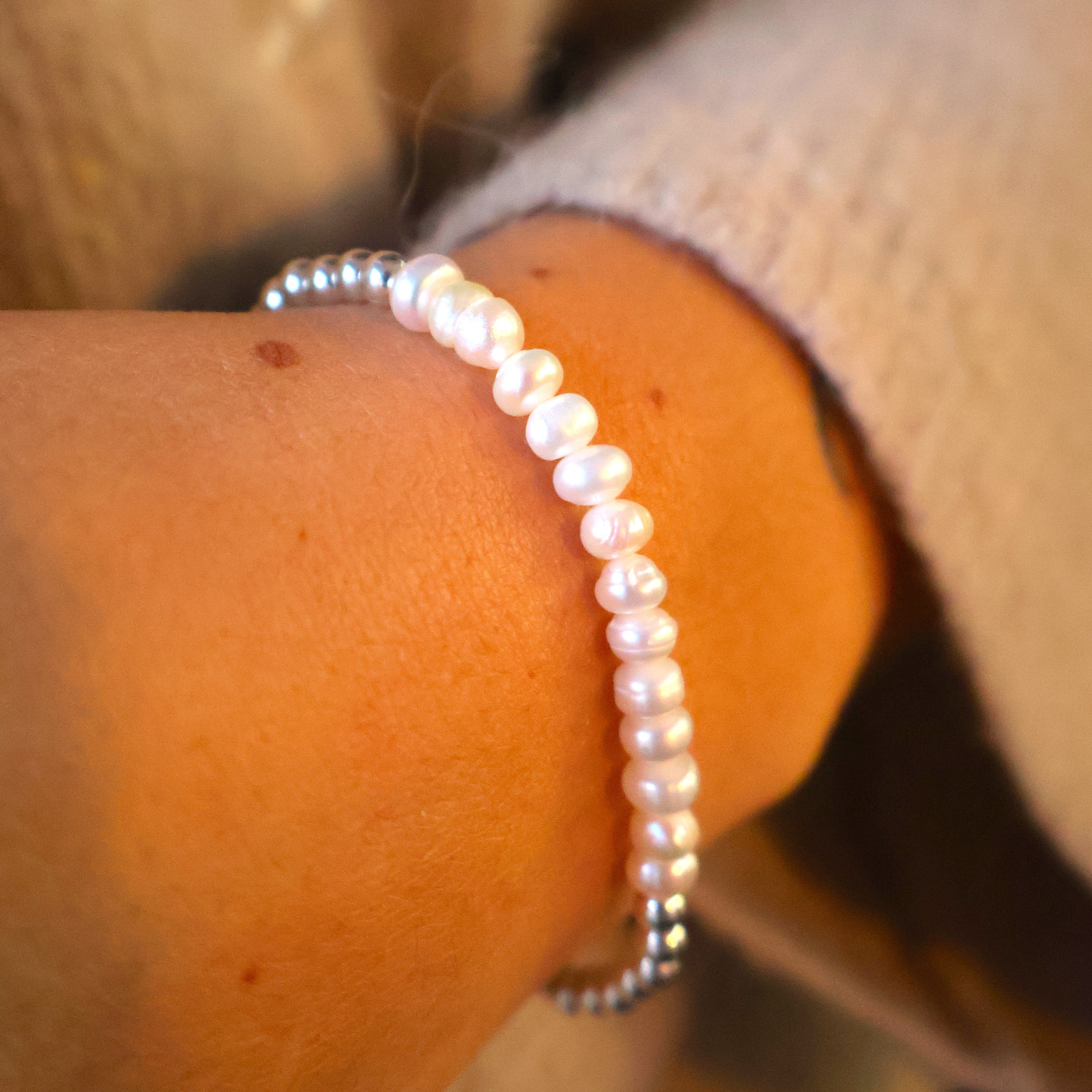 zilveren armband met in het midden ovale pareltjes